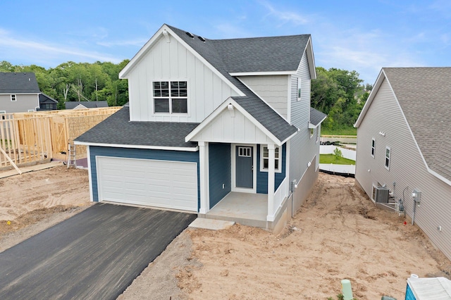 1595 76th St W, Inver Grove Heights, MN 55077 - view of front of property featuring board and batten siding, a shingled roof, central AC unit, driveway, and a garage