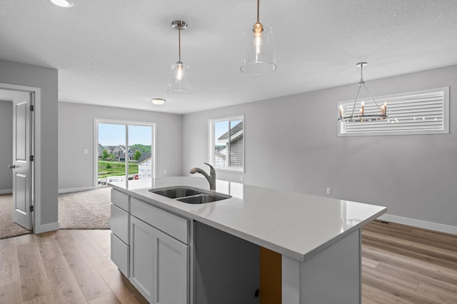 1595 76th St W, Inver Grove Heights, MN 55077 - kitchen featuring a sink, light wood-style floors, light countertops, and hanging light fixtures