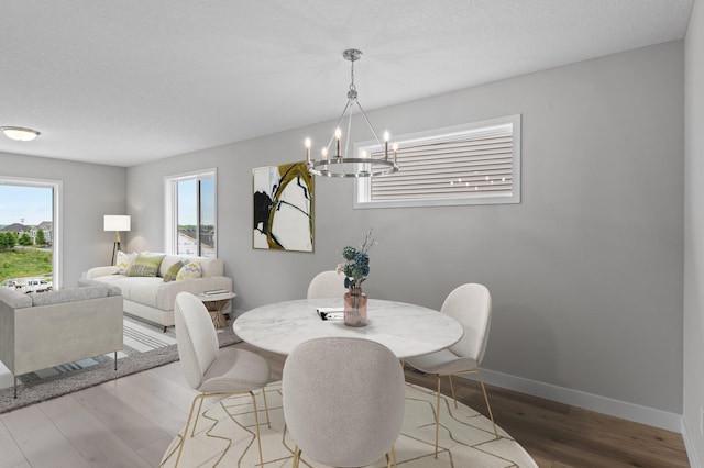 1595 76th St W, Inver Grove Heights, MN 55077 - dining area with a chandelier, wood finished floors, and baseboards