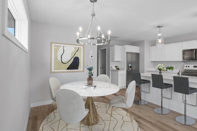 1595 76th St W, Inver Grove Heights, MN 55077 - dining room featuring a chandelier, light wood-type flooring, and baseboards
