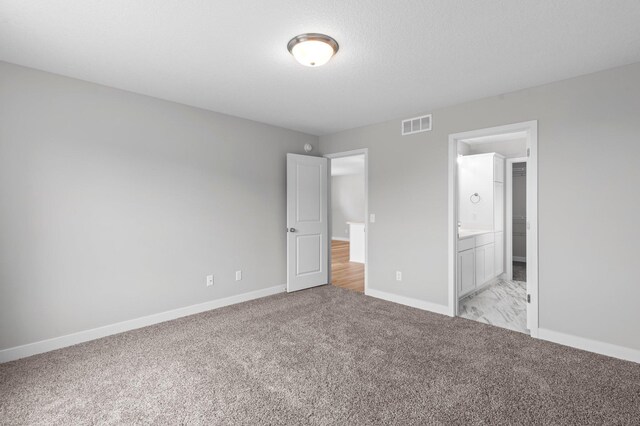 1595 76th St W, Inver Grove Heights, MN 55077 - unfurnished bedroom with light carpet, baseboards, and ensuite bath
