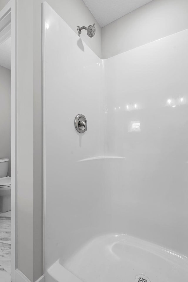 1595 76th St W, Inver Grove Heights, MN 55077 - bathroom featuring toilet, marble finish floors, and a shower