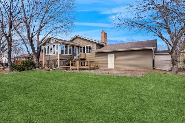 back of property featuring a wooden deck, a sunroom, a lawn, fence, and a chimney