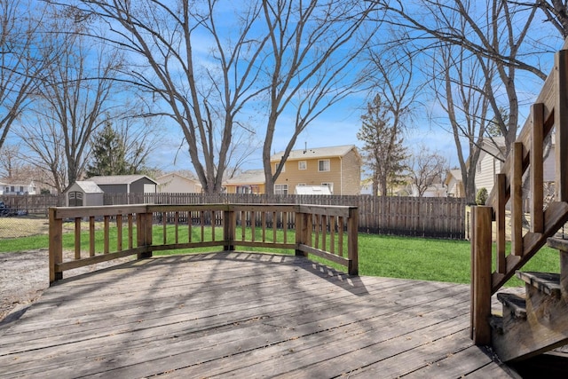 wooden deck featuring a yard, a fenced backyard, and a residential view