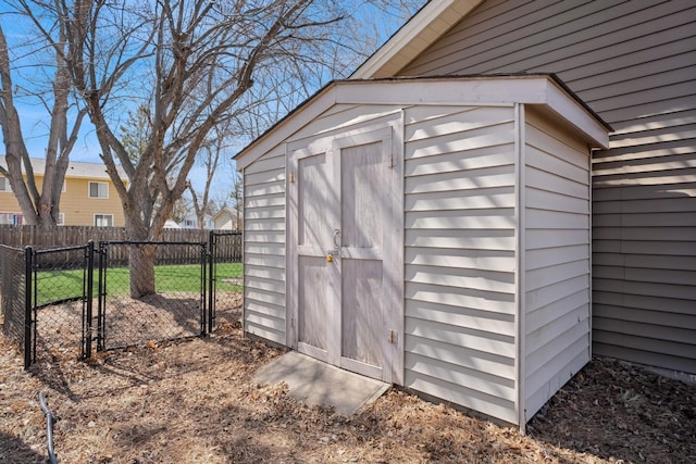 view of shed featuring fence and a gate
