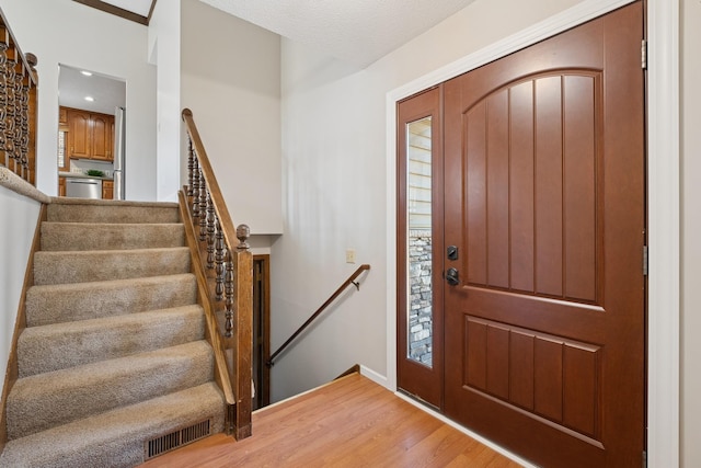 entryway featuring recessed lighting, stairway, visible vents, and light wood-type flooring