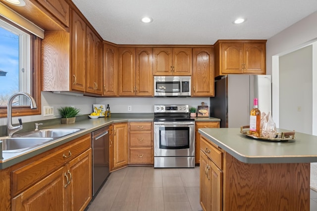 kitchen with brown cabinets, appliances with stainless steel finishes, and a sink