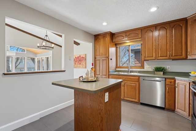 kitchen with stainless steel appliances, brown cabinets, a sink, and a chandelier