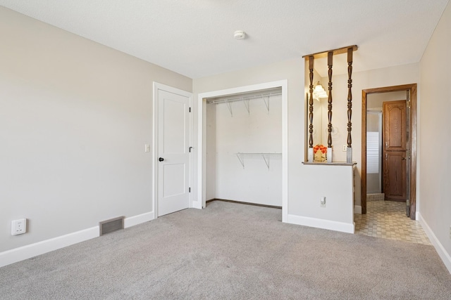 unfurnished bedroom featuring baseboards, visible vents, carpet floors, and a closet