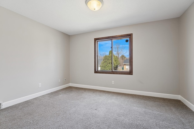spare room featuring carpet, visible vents, and baseboards