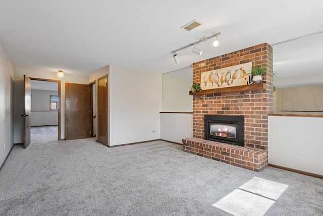 unfurnished living room with baseboards, a brick fireplace, visible vents, and carpet floors