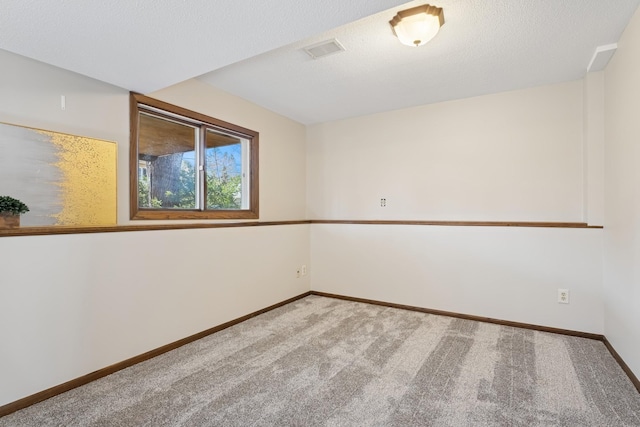 spare room featuring baseboards, visible vents, and carpet floors
