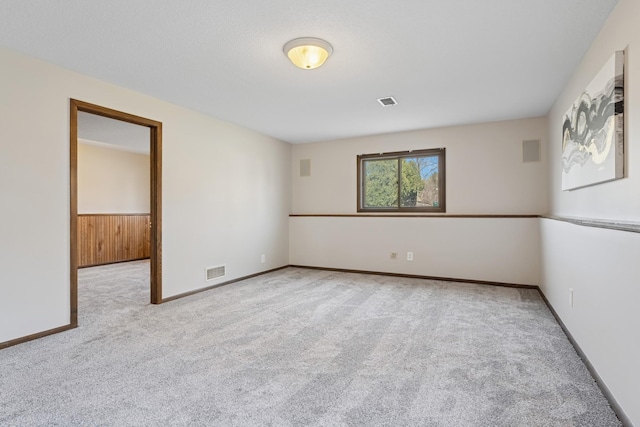 empty room with baseboards, visible vents, and carpet