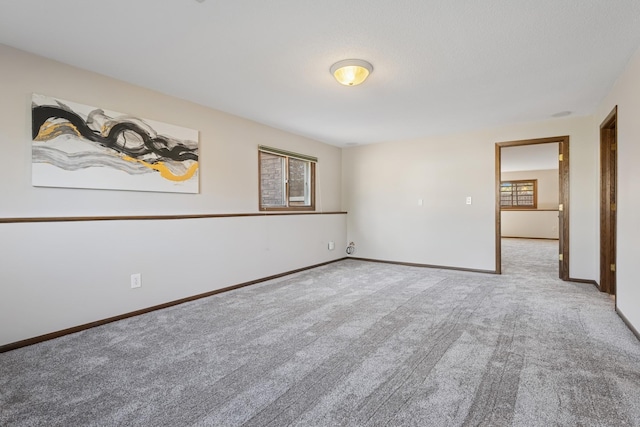 unfurnished room with baseboards and carpet floors