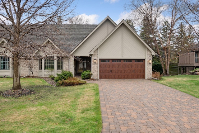 view of front facade with an attached garage, a front yard, decorative driveway, and brick siding