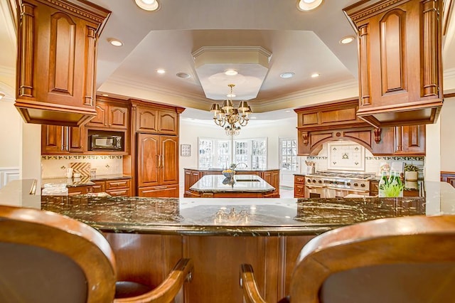 4927 Lake Ave, White Bear Lake, MN 55110 - kitchen with range with two ovens, black microwave, a peninsula, dark stone countertops, and a tray ceiling
