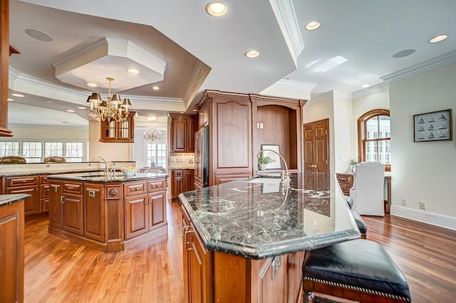 4927 Lake Ave, White Bear Lake, MN 55110 - kitchen featuring an inviting chandelier, a center island with sink, light wood finished floors, stainless steel fridge, and ornamental molding