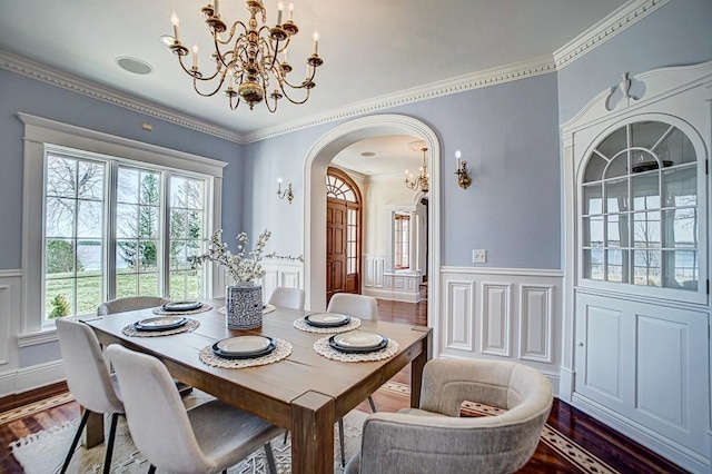 4927 Lake Ave, White Bear Lake, MN 55110 - dining room featuring an inviting chandelier, arched walkways, a decorative wall, and a healthy amount of sunlight
