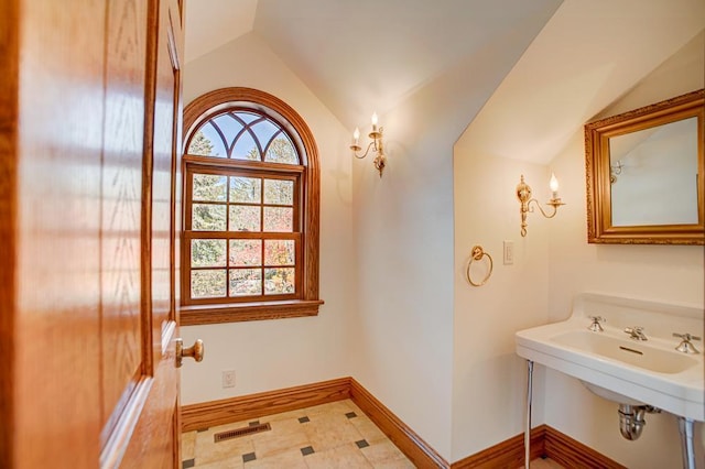 4927 Lake Ave, White Bear Lake, MN 55110 - bathroom with baseboards, a sink, and lofted ceiling