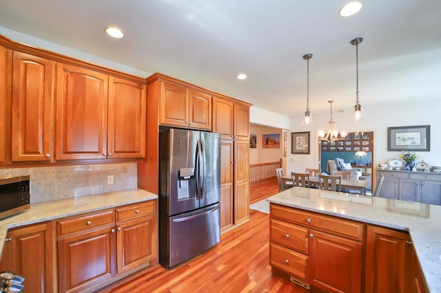 6203 Fairfax Ct, Baxter, MN 56425 - kitchen featuring stainless steel appliances, a chandelier, light wood-type flooring, decorative light fixtures, and light stone countertops