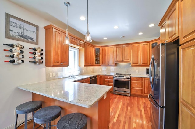6203 Fairfax Ct, Baxter, MN 56425 - kitchen featuring stainless steel appliances, a peninsula, glass insert cabinets, light wood-style floors, and tasteful backsplash