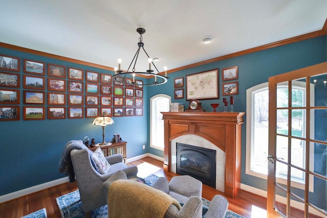 6203 Fairfax Ct, Baxter, MN 56425 - sitting room with baseboards, a chandelier, a glass covered fireplace, crown molding, and wood finished floors