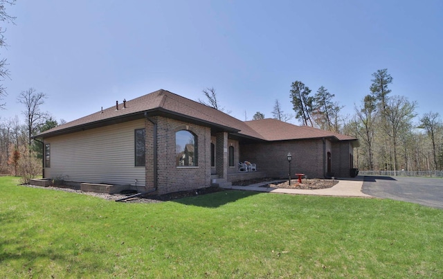 6203 Fairfax Ct, Baxter, MN 56425 - view of side of home featuring a yard, asphalt driveway, and brick siding