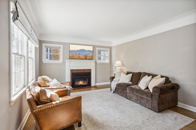 living area featuring a brick fireplace, wood finished floors, and baseboards