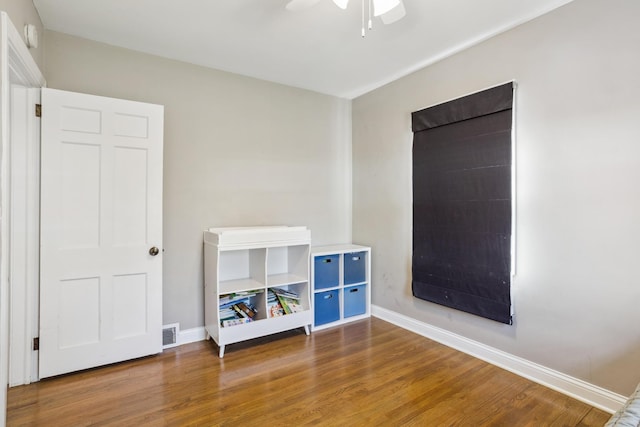 unfurnished bedroom with wood finished floors, baseboards, and a ceiling fan
