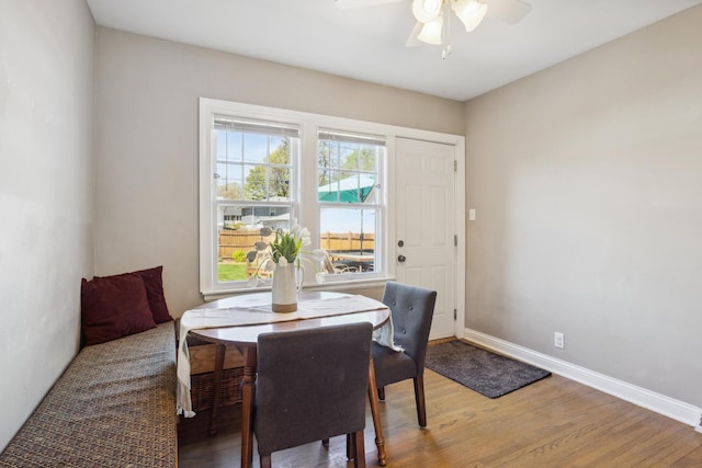 dining room with a ceiling fan, light wood-style flooring, and baseboards