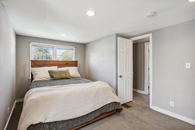 carpeted bedroom featuring baseboards and recessed lighting