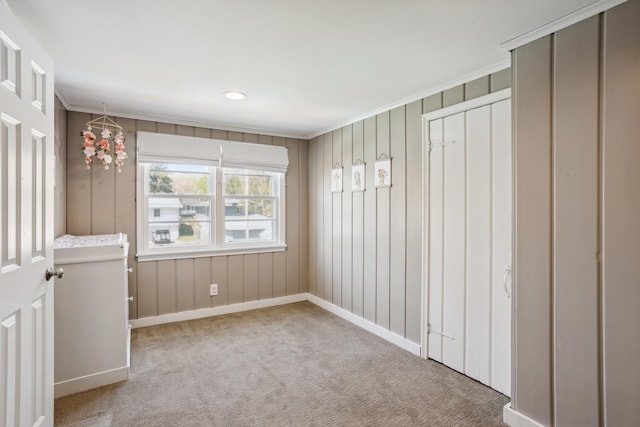 unfurnished bedroom with carpet flooring, crown molding, and baseboards