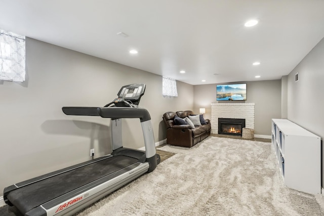 exercise room with a brick fireplace, recessed lighting, and baseboards