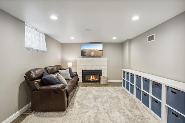 living area with a fireplace, baseboards, recessed lighting, and wood finished floors