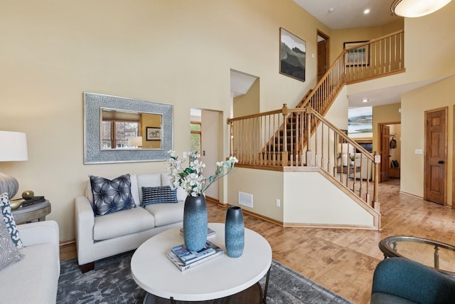 4633 Stonecliffe Dr, Eagan, MN 55122 - living area featuring stairs, wood finished floors, a towering ceiling, and baseboards