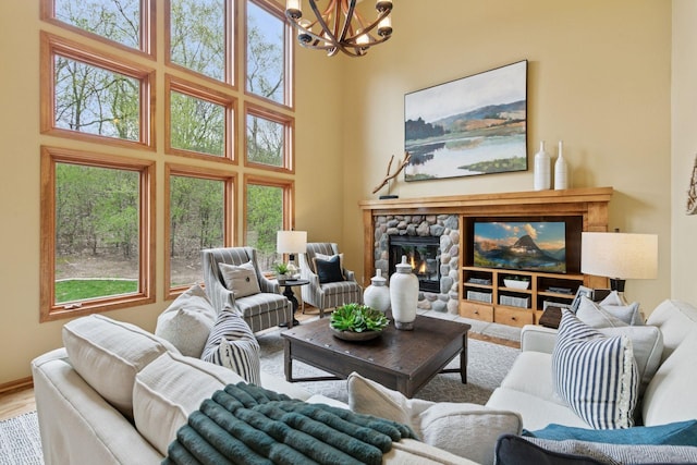 4633 Stonecliffe Dr, Eagan, MN 55122 - living area featuring a chandelier, a towering ceiling, a stone fireplace, and healthy amount of natural light