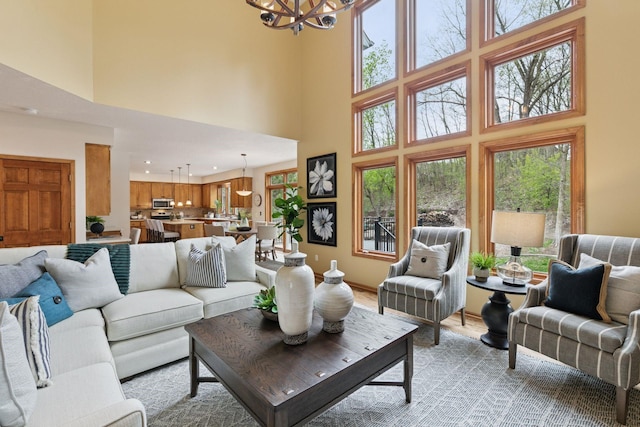 4633 Stonecliffe Dr, Eagan, MN 55122 - living room featuring a chandelier, a towering ceiling, recessed lighting, and light wood finished floors