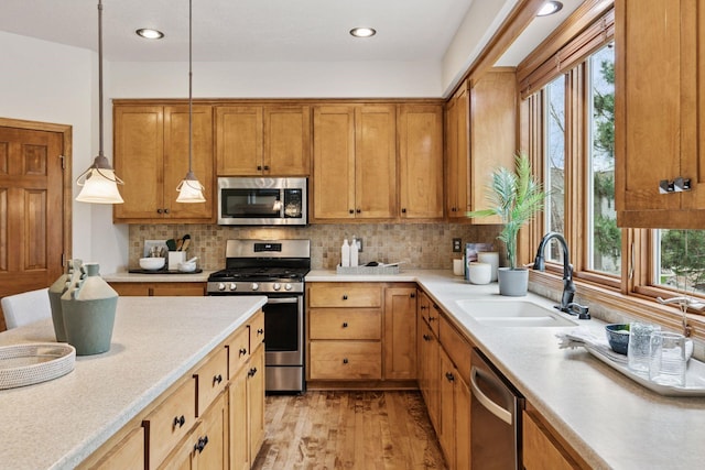 4633 Stonecliffe Dr, Eagan, MN 55122 - kitchen featuring appliances with stainless steel finishes, a sink, light countertops, light wood-style floors, and recessed lighting