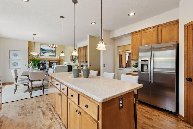 4633 Stonecliffe Dr, Eagan, MN 55122 - kitchen with stainless steel refrigerator with ice dispenser, a kitchen island, light wood-style flooring, decorative light fixtures, and recessed lighting
