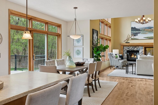 4633 Stonecliffe Dr, Eagan, MN 55122 - dining room with a fireplace, a chandelier, and light wood-type flooring