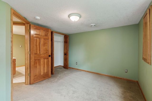 4633 Stonecliffe Dr, Eagan, MN 55122 - unfurnished bedroom featuring light colored carpet, a textured ceiling, baseboards, and a closet