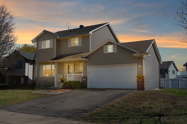 traditional home featuring fence, an attached garage, brick siding, covered porch, and driveway