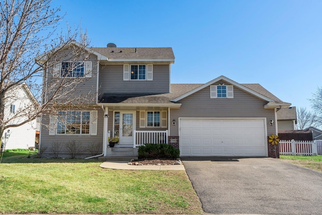 traditional home featuring a front lawn, fence, an attached garage, driveway, and a porch