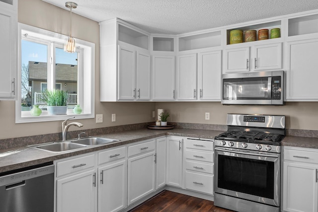 kitchen featuring white cabinetry, open shelves, appliances with stainless steel finishes, and a sink