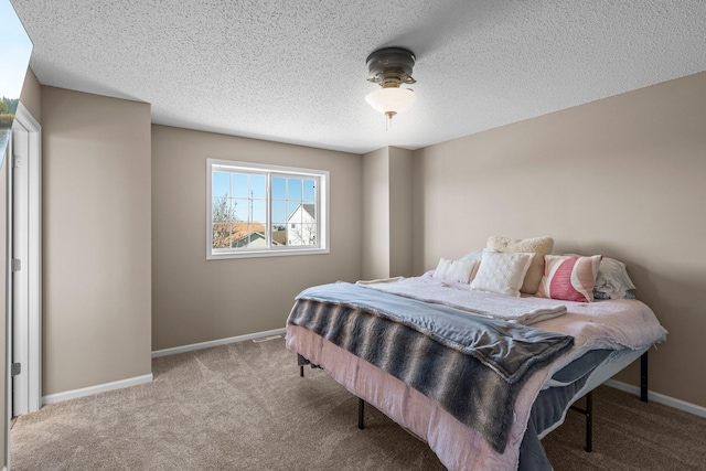 bedroom with carpet floors, a textured ceiling, and baseboards