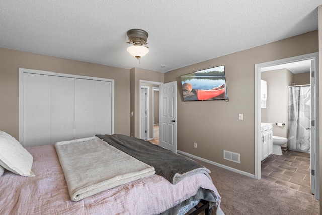 bedroom featuring carpet floors, baseboards, ensuite bathroom, visible vents, and a closet