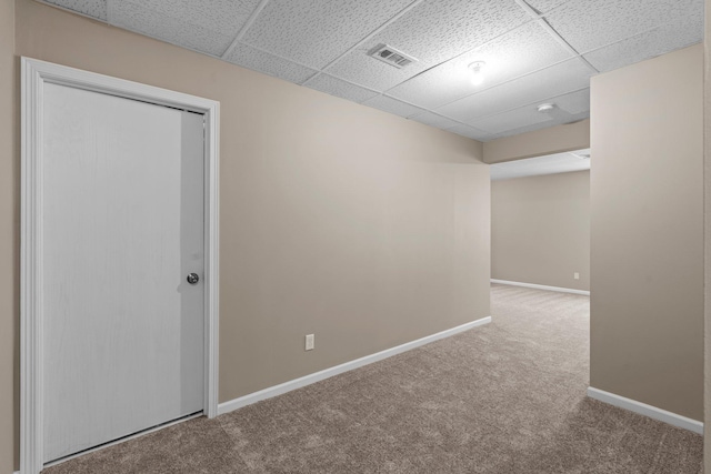 unfurnished room with carpet floors, baseboards, a drop ceiling, and visible vents