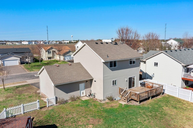 rear view of property with a yard, a residential view, a wooden deck, and a fenced backyard
