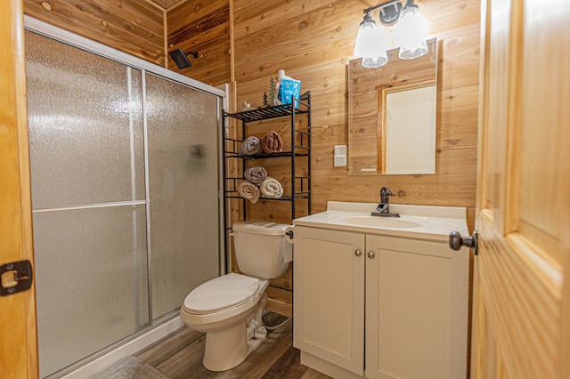20462 Little Alps Rd NW, Evansville, MN 56326 - bathroom featuring wooden walls, a shower stall, toilet, vanity, and wood finished floors