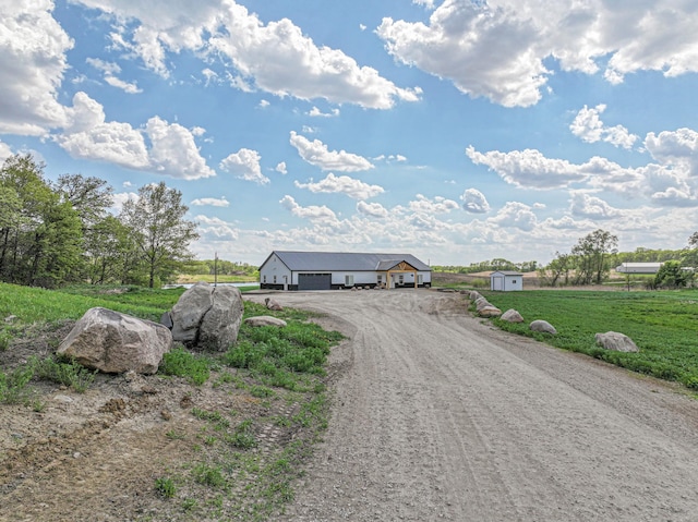 20462 Little Alps Rd NW, Evansville, MN 56326 - view of front of house featuring dirt driveway, a garage, an outdoor structure, and a front lawn